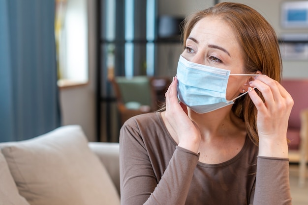 Woman with mask staying in quarantine looking away