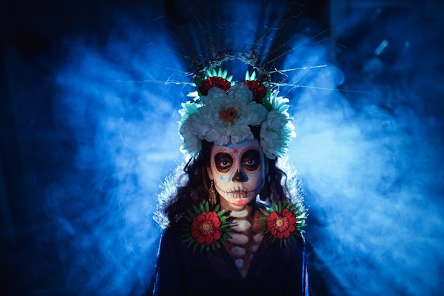 Woman with mexican skull halloween makeup on her face. Day of the dead and halloween