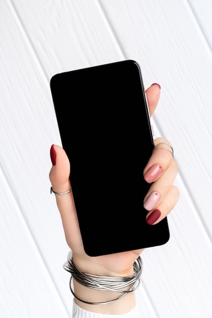 Woman with minimal pink spring summer manicure design holding smartphone. Work from home female business concept