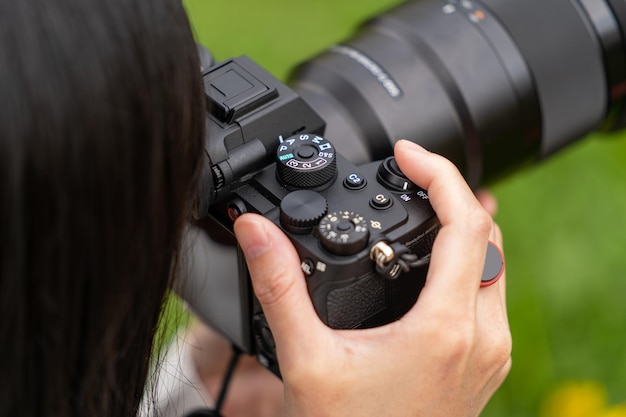 Photo woman with a mirrorless interchangeable-lens camera