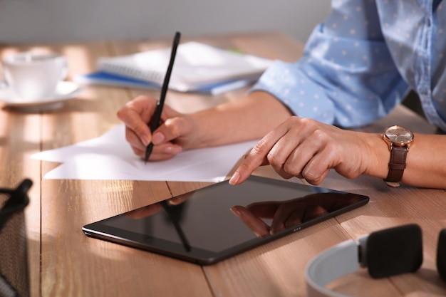 Woman with modern tablet learning at table indoors closeup