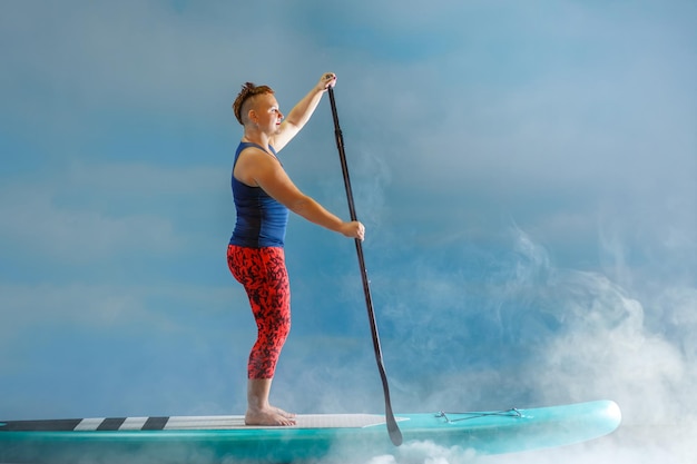 A woman with a mohawk on a snowboard in the fog against the background of clouds