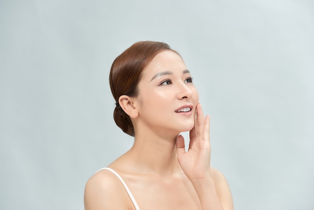 Woman with a natural beauty makeup look - isolated over a light blue background