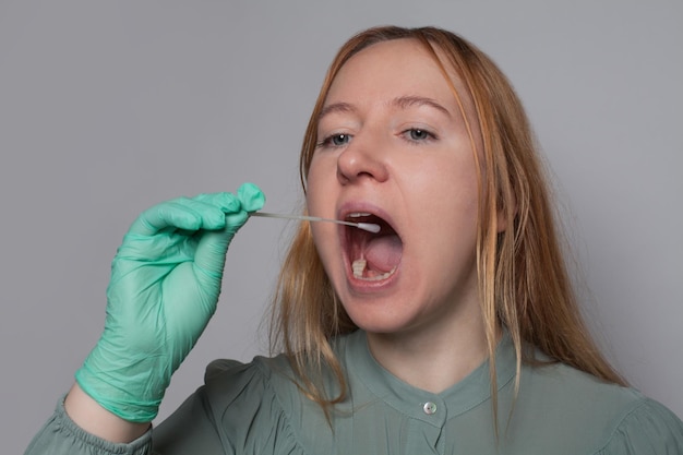 Photo woman with open mouth using home coronavirus test kit medicine health and covid19 concept