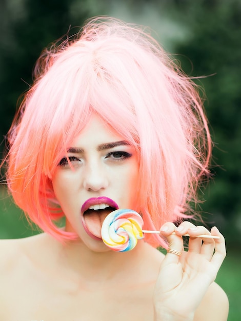 Woman with orange hair lick lollipop