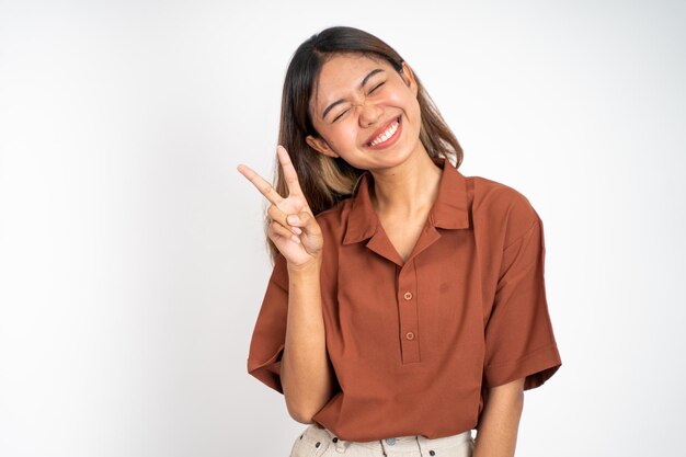 Woman with peaceful hand gesture on isolated background