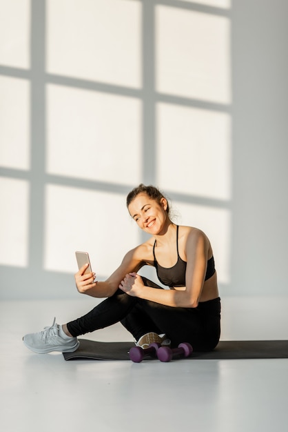 Woman with phone on a fitness training