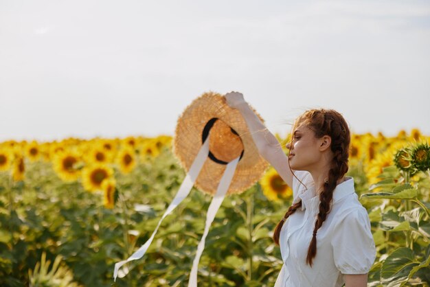 Woman with pigtails In a field with blooming sunflowers landscape