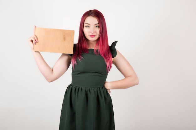 Woman with pink hair on white holding book