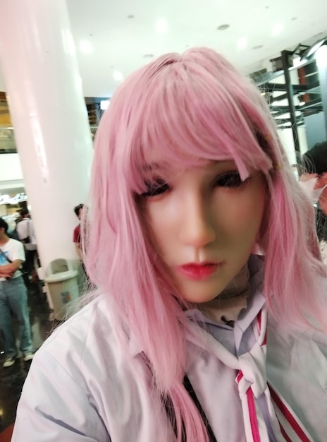 a woman with pink hair and a white shirt has a pink nose