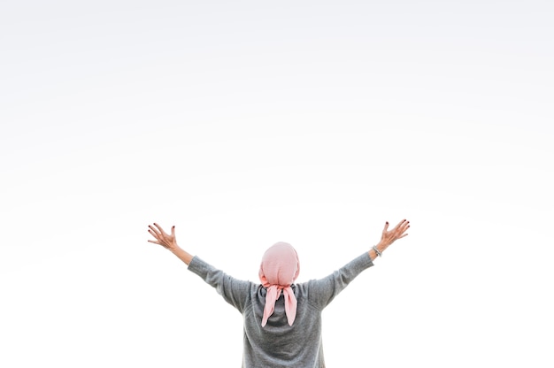 Woman with pink headscarf looking at the horizon. Cancer concept