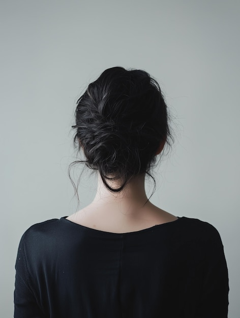 a woman with a ponytail is standing in front of a white background