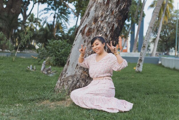 Woman with positive attitude seated in the grass in a public garden