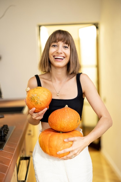 Woman with pumpkins in kitchen