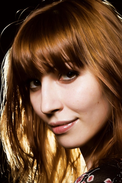 Woman with red hair over black background