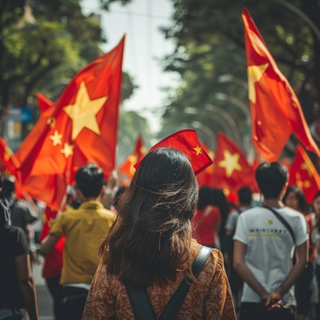 a woman with a red hat is walking in a parade with red flags