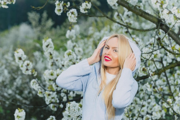 Woman with red lips and blonde hair in blossom