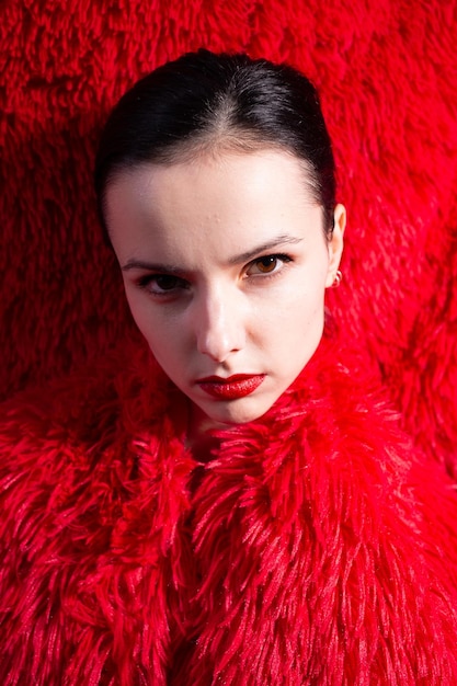 woman with red lips in red fluffy clothes red fluffy background