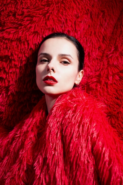 woman with red lips in red fluffy clothes red fluffy background