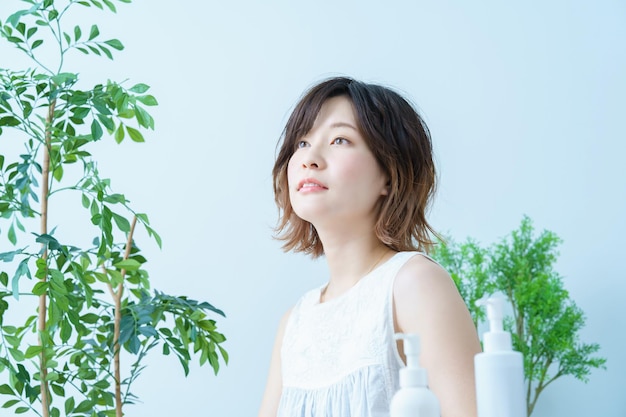 A woman with a relaxed look surrounded by plants