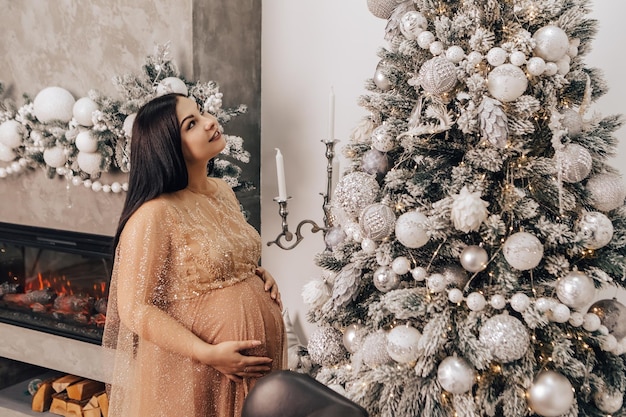 Woman with round belly with baby kid inside decorating Christmas Tree, celebrating New Year holiday