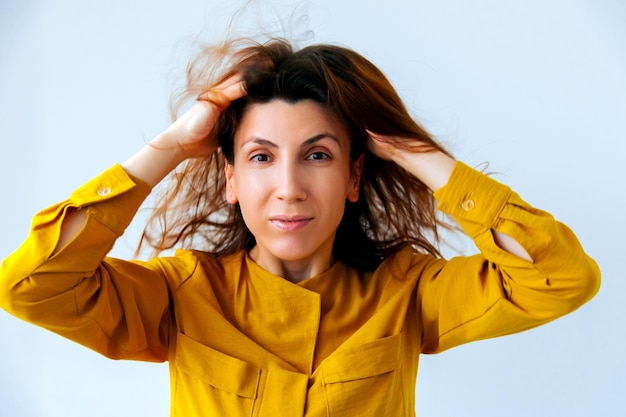 A woman with ruffled hair grabbed her head damaged dry woman hair closeup isolated on white backgrou