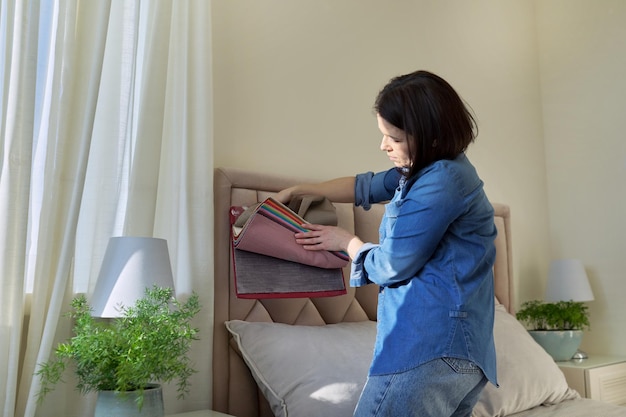 Woman with samples of interior fabrics choosing fabrics for upholstery curtains