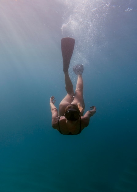 Woman with scuba gear swimming in the ocean