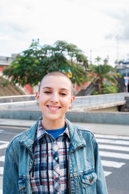 Woman with shaved hair smiling with the city in the background Concept Lifestyle feminism city