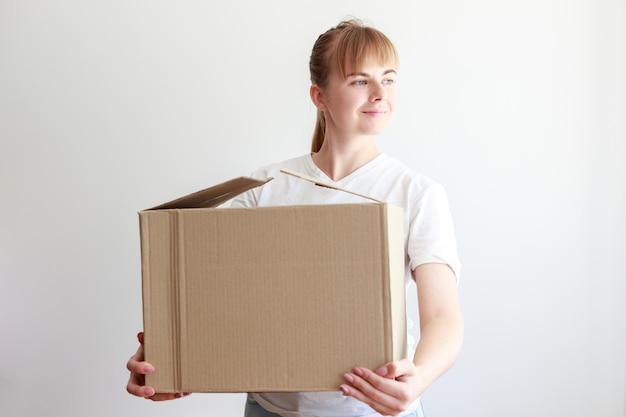 Woman with shipping cardboard box looks away