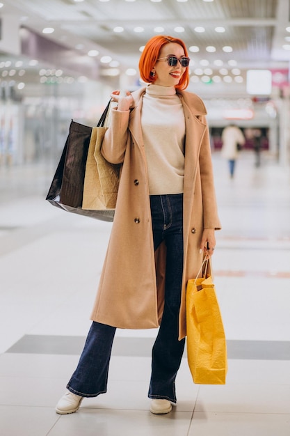 Woman with shopping bags making purchases in mall