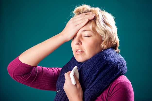 Woman with short blond hair got the flu and has a headache. People, healthcare and medicine concept