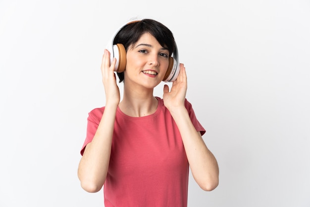 Woman with short hair over isolated wall listening music