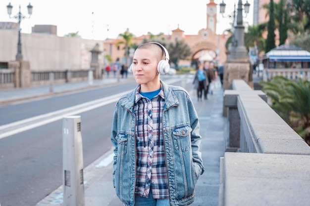 Woman with short hair walking through the city listening to her music and enjoying an afternoon walk Concept Lifestyle music free