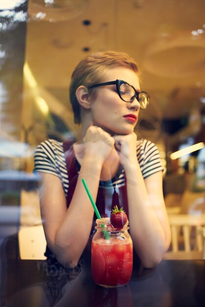 Woman with short hairstyle in a cafe cocktail rest pensive look High quality photo