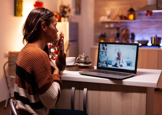 Woman with sickness calling doctor on online video conference