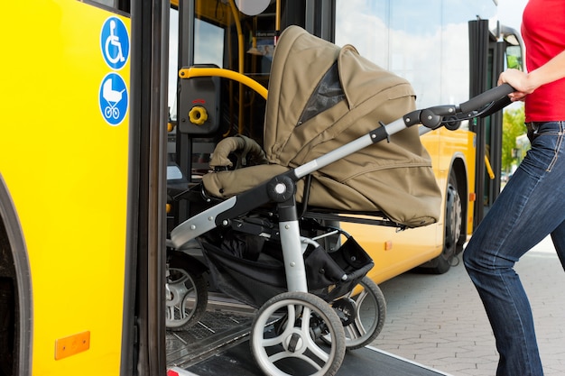 Woman with stroller getting into a bus