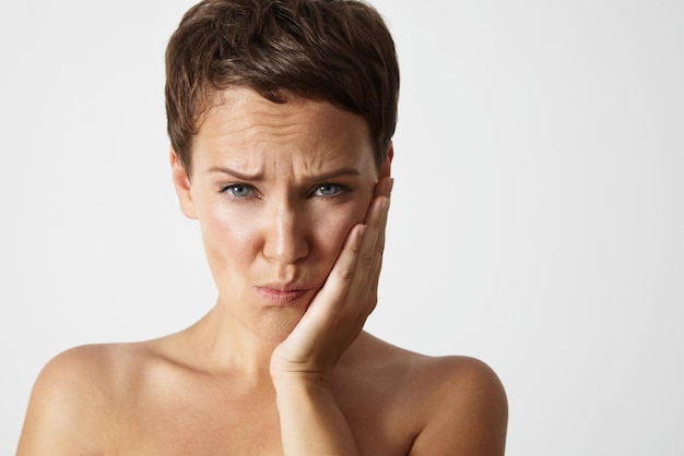 Woman with a teeth pain holding her cheek