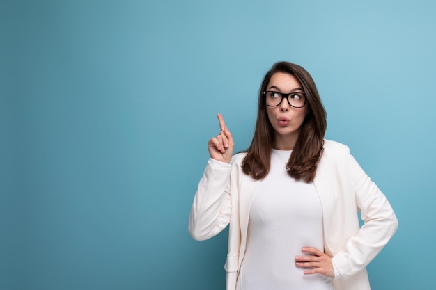 Photo woman with thick dark hair in an office outfit on a blue studio background