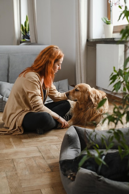 Woman with three dogs cuddling on the floor