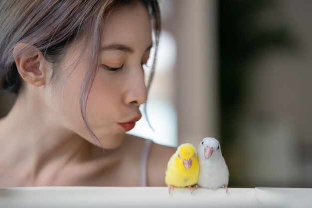 Woman with tiny parrot parakeet yellow and white Forpus bird