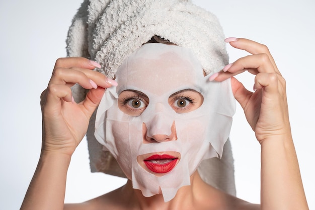 Woman with a towel on her hair and a mask on her face skin and hair care