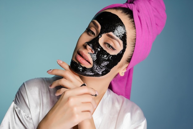 Woman with a towel on her head applied a mask to clean the face skin