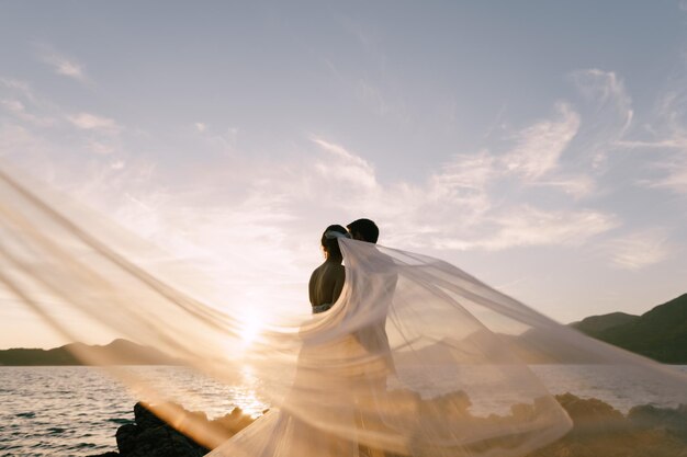 Photo woman with umbrella against sky during sunset