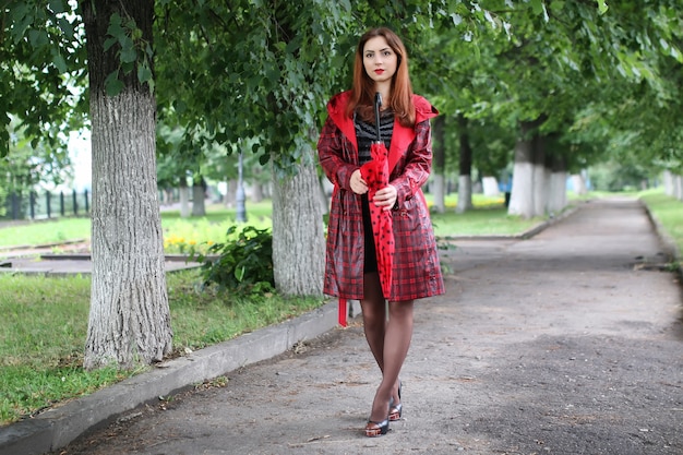 Woman with umbrella red on street tree