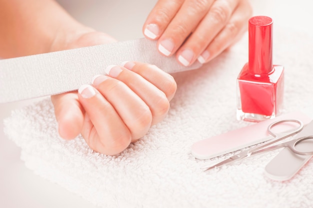 Woman with well manicured nails on white