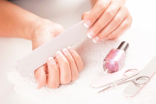 Woman with well manicured nails on white