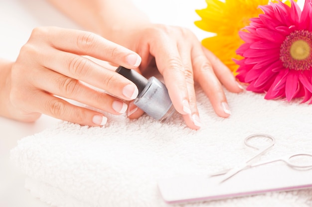 Woman with well manicured nails on white