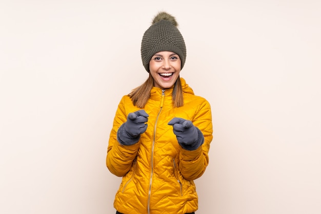 Woman with winter hat over wall points finger