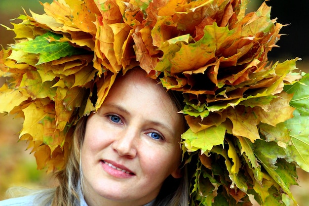 Woman with yellow autumn leaves on the head